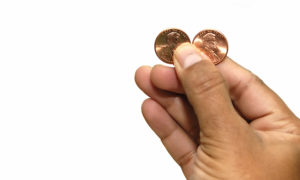 hand holding two pennies