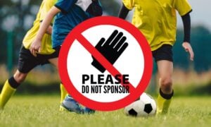 kids playing soccer with do not sponsor sign