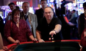 A customer rolls dice at a craps table at Resorts World Catskills, one of four upstate commercial casinos in New York that have helped the industry potentially set a record for single-year revenue.