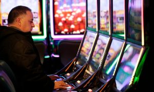 man at slot machine at resorts world catskills in new york