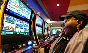 Woman plays slots at Resorts World NYC for a story on Resorts World and Empire City Casino as well as other racinos closing Tuesday for system upgrades