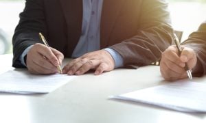 Businessmen sign contracts for a story on the Seneca Nation of Indians looking for a new gaming compact with New York.