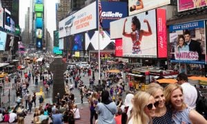 Tourists visit Times Square in New York for a story on a growing group of detractors opposing a proposed Caesars Palace casino.