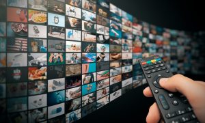 Image of a remote control in front of TVs for a story on a New York Assembly bill aiming to restrict advertising by sportsbooks.